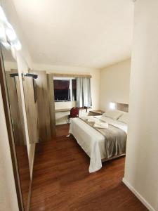 a hotel room with a bed and a window at LH Plaza Hotel in Chapecó +48 photos