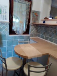 a kitchen with a wooden table and two chairs at Chic Casa al Mare in Basilicata in Marina di Pisticci +8 photos