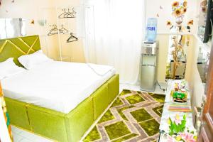 a bedroom with a green bed in a room at Le Cristal de Roche in Pointe-Noire