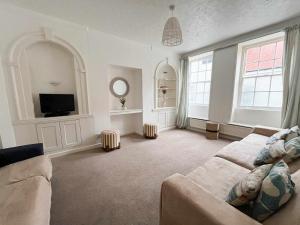 ein Wohnzimmer mit Sofa und Fernseher in der Unterkunft Admiralty House in Weymouth