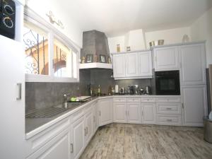 Eine Küche mit weißen Schränken, Spüle und Herd in der Unterkunft Holiday Home in Var near Beaches & Pool in Saint-Tropez