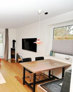 a dining room with a table and a tv at Möwenweg Die Möwe im Möwenweg App 1 in Hohwacht
