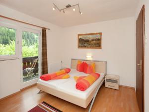 a bedroom with a bed with orange and yellow pillows at Holiday Home in Wenns near Ski Lift in Wenns