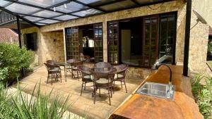 a patio with chairs and tables on a patio at Casa 03 Vale Boa Vista - Charme Rústico em Condomínio com Área de Lazer Completa in Teresópolis