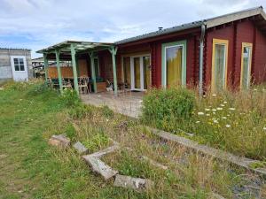 a red house on a hill with a yard at Petit Chalet en Baie de Somme in Saint-Valery-sur-Somme