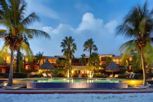 un complejo con piscina y palmeras en Villa Devries C4 Jan Thiel Private Beachfront Pool, en Willemstad