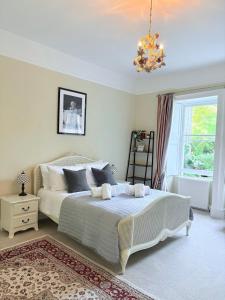 a bedroom with a bed and a chandelier at Large Quiet City Centre Holiday Home in Great Pulteney St, Bath in Bath