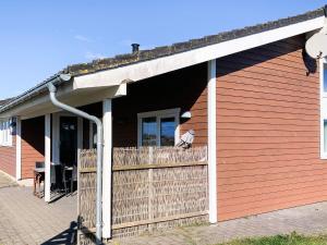 a red building with a fence and a porch at 10 person holiday home in Thisted-By Traum in Klitmøller