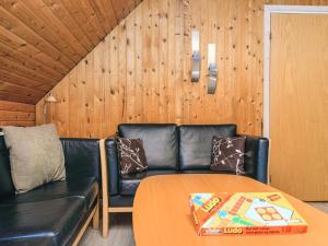 a living room with a leather couch and a table at Tranquil Haven in Ansager - By Traum Ferienwohnungen in Ansager +17 photos