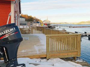 a snow covered wooden dock with a scooter parked on it at 4 star holiday home in Oksvoll in Oksvoll