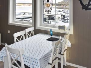 a dining room table and chairs with a table and windows at 4 star holiday home in Oksvoll in Oksvoll +28 photos