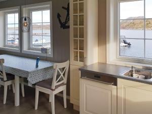 a kitchen with a table and chairs and a sink at 6 person holiday home in Oksvoll in Oksvoll +29 photos