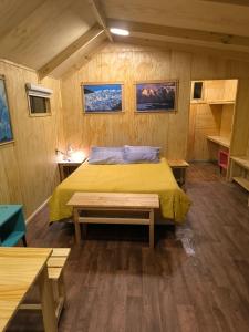 a bedroom with a yellow bed in a room at Isla yu backpacker in Puerto Natales