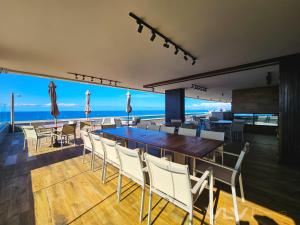 a dining room with a table and chairs and the ocean at Residencial Premium Stella Maris by VLV Stays in Salvador