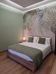 カステッランマーレ・ディ・スタービアにあるNina's houseのベッドルーム1室(葉の壁画付)