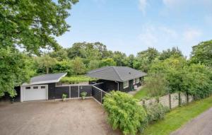 dom z garażem i ogrodzeniem w obiekcie Cozy Cottage Just 300 M From Høve Beach w mieście Asnæs
