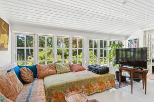 un salon avec un canapé et une télévision à écran plat dans l'établissement Family-Friendly Cottage Near Beach & Nature, à Vejby