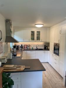 a kitchen with white cabinets and a black counter top at Fjord Home Near Preikestolen in Strand