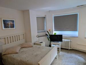 a bedroom with a bed and a flat screen tv at Central and convenient studio near supermarkets and public transports in Brussels