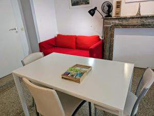 a living room with a white table with a red couch at Central and convenient studio near supermarkets and public transports in Brussels +7 photos