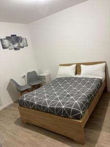 a bedroom with a bed and a chair at Studio Bethel cosy à Villejuif centre Paris in Villejuif