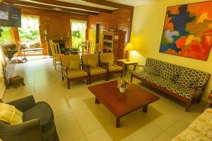 a living room with couches and chairs and a table at Sítio Bem me Quer seu conforto e relax na Serrinha in Penedo
