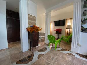a living room with green chairs and a table at Recidencial sharael house in San Isidro