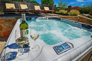 a hot tub with wine glasses and a bottle of wine at Holiday Home Gašparini in Višnjan