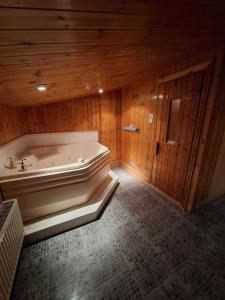 a bath tub in a room with a wooden wall at Alice house in Sunderland