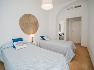 Dos camas en una habitación con paredes blancas. en Sibs Sanlucar Fariñas 11-15 - Historical building, en Sanlúcar de Barrameda