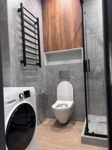 a small bathroom with a toilet and a washing machine at Апартаменти біля моря in Odesa