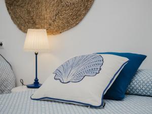 una almohada sentada en una cama junto a una lámpara en Sibs Sanlucar Fariñas 11-15 - Historical building, en Sanlúcar de Barrameda