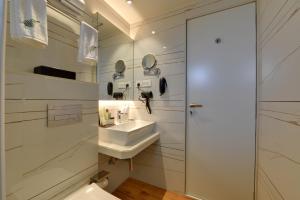 a white bathroom with a sink and a toilet at The Fern Residency Mira Road,Mumbai in Mumbai +30 photos