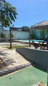 a patio with a table and a bench next to a pool at Pousada Barlavento - Ilha Grande - Porto dos Tatus - Delta do Parnaíba - Piscina e Conforto in Ilha Grande de Santa Isabel