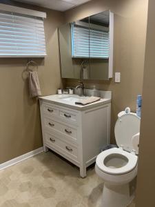 Un baño con inodoro, lavabo y espejo. en Curtis Creek Lakehouse, en Junction City