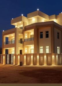 a large white building with a fence in front of it at شقق وفلل بيوت السلام in Salalah