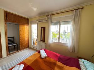 a bedroom with a bed with a colorful blanket on it at ADA & Gran Alacant & Vacation in Gran Alacant +39 photos