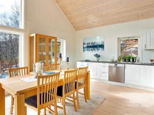 a large kitchen with a wooden table and chairs at 4 star holiday home in Valevåg in Valevåg