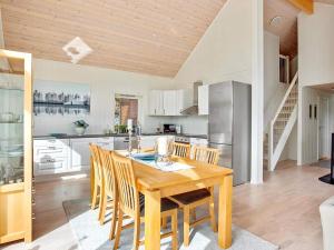 a kitchen with a wooden table and chairs at 4 star holiday home in Valevåg in Valevåg