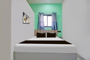 a bedroom with a large bed with a window at Hotel O Galaxy Stay in Chandrapur