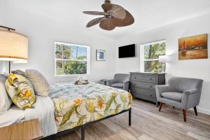 a bedroom with a bed and two chairs and a fan at Buffalo Bungalow in Clearwater Beach