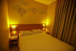 a bedroom with a bed with two pillows on it at Hotel Dan Inn São Carlos By Nacional Inn in São Carlos +28 photos