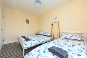 a bedroom with two beds and a lamp at Hunstanton Holidays Flat 3 with seaview in Hunstanton