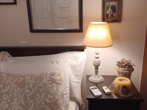 a lamp on a table next to a bed at Maisonette on the beach with small garden in AgiaKampos