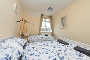 a bedroom with two beds and a ladder and a window at Hunstanton Holidays Flat 3 with seaview in Hunstanton