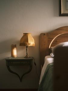 a lamp on a table next to a bed at Villa Montalban Ghetti - La Fiorita in Conegliano