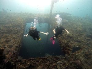 two people swimming in the water in the ocean at Dhita Bila Bungalows & Dive in Amed +7 photos
