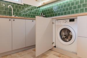 a washing machine in a kitchen with green tiles at TripON cozy spot in Cluj-Napoca