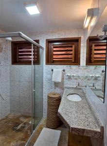 a bathroom with a sink and a glass shower at Azul Flats in Jericoacoara