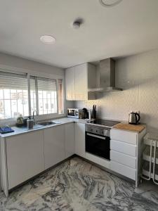 a kitchen with white cabinets and a black appliance at Golden Hour Grupo AC Gestión in Rota